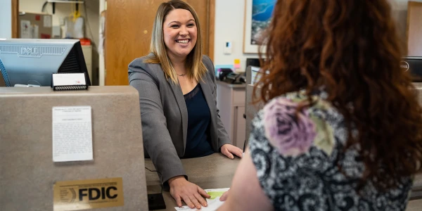 Smiling bank associate with customer.