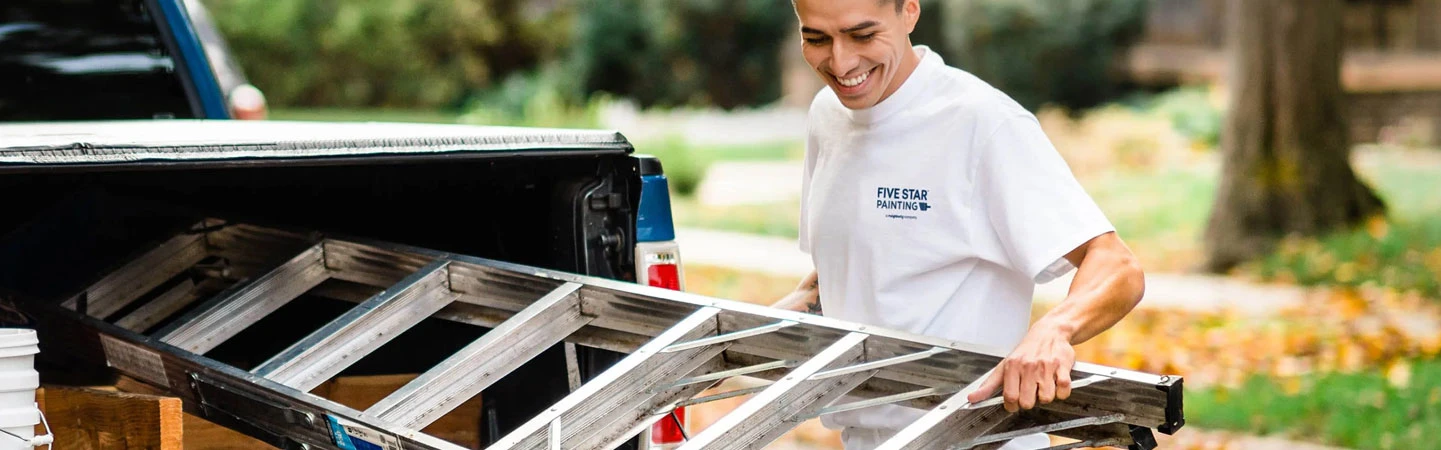 Five Star Painting employee loading ladder into a truck